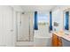 Bright bathroom with a glass-enclosed shower, soaking tub, and vanity at 7032 Wonderberry St, Las Vegas, NV 89131