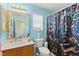 Charming blue bathroom featuring a decorative shower curtain, vanity, and bright natural light at 7032 Wonderberry St, Las Vegas, NV 89131