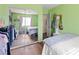 Spacious bedroom with a comfy queen bed, mirrored closet doors, and bright green accent walls at 7032 Wonderberry St, Las Vegas, NV 89131