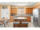 Traditional-style kitchen features an island, stainless appliances, wood cabinetry and tiled backsplash at 7032 Wonderberry St, Las Vegas, NV 89131