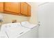 Functional laundry room with top-loading washer and dryer, with wooden cabinets at 7032 Wonderberry St, Las Vegas, NV 89131