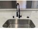 Close-up of a stainless steel kitchen sink with modern black faucet and quartz countertop at 8101 W Flamingo Rd # 1102, Las Vegas, NV 89147