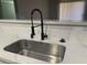 Modern kitchen sink featuring a stainless steel basin, black faucet, and elegant quartz countertop at 8101 W Flamingo Rd # 1102, Las Vegas, NV 89147