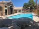 Community pool with tables, chairs, and lounge chairs surrounded by community buildings at 8101 W Flamingo Rd # 1102, Las Vegas, NV 89147