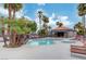 Beautiful community pool area with lounge chairs, tropical landscaping, and a covered seating area for residents at 8600 W Charleston Blvd # 1059, Las Vegas, NV 89117