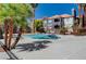 Community pool with palm trees and lounge seating near apartments on a sunny day at 8600 W Charleston Blvd # 1059, Las Vegas, NV 89117