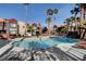 Community pool with rock waterfall feature, palm trees, and lounge seating near apartments at 8600 W Charleston Blvd # 1059, Las Vegas, NV 89117
