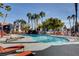 Community pool with rock waterfall feature, palm trees, and lounge seating near apartments at 8600 W Charleston Blvd # 1059, Las Vegas, NV 89117