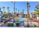 Aerial view of a community pool surrounded by palm trees, apartments, and a secure fence at 8600 W Charleston Blvd # 1059, Las Vegas, NV 89117