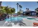 Community pool and spa with rock waterfall feature, palm trees, and lounge seating at 8600 W Charleston Blvd # 1059, Las Vegas, NV 89117
