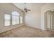 Spacious bedroom with a ceiling fan, archways, neutral carpet, and plenty of natural light at 8768 Tom Noon Ave # 101, Las Vegas, NV 89178