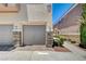 Attached garage with stone accents and neutral paint offer convenient parking and curb appeal at 8768 Tom Noon Ave # 101, Las Vegas, NV 89178