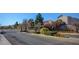 A street leading to a gated community entrance shows beautiful landscaping and well-maintained surroundings at 8768 Tom Noon Ave # 101, Las Vegas, NV 89178