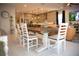 Open concept dining room featuring a wooden table, white chairs, and modern lighting, seamlessly connecting to the kitchen at 879 Klamath Springs St, Henderson, NV 89011