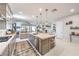 Modern kitchen with island seating, stainless steel appliances, and open living area at 879 Klamath Springs St, Henderson, NV 89011