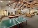 Large recreation area with ping pong and pool tables plus comfy seating and a fireplace, ideal for socializing at 9050 Warm Springs Rd # 2050, Las Vegas, NV 89148