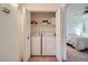 Convenient laundry closet with a side-by-side washer and dryer and storage shelves at 9050 Warm Springs Rd # 2050, Las Vegas, NV 89148