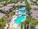 Aerial view of a large community pool with palm trees and lounge areas, perfect for relaxation at 9050 Warm Springs Rd # 2050, Las Vegas, NV 89148