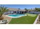 A beautiful backyard featuring a sparkling pool, putting green and covered patio at 9100 Shelter Cove Ct, Las Vegas, NV 89117