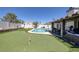 Beautiful backyard with a putting green, pool, and covered patio, perfect for outdoor enjoyment at 9100 Shelter Cove Ct, Las Vegas, NV 89117