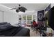Comfortable bedroom with a cozy bed, ceiling fan, a bay window, and personal decor at 9100 Shelter Cove Ct, Las Vegas, NV 89117