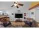 Open living room with tile flooring, large TV, and comfortable sectional sofa at 9100 Shelter Cove Ct, Las Vegas, NV 89117