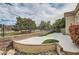 Landscaped backyard with retaining wall and mature trees providing privacy and shade at 916 Pro Players Dr, Las Vegas, NV 89134