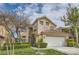 Charming two-story home with a well-maintained lawn, mature trees, and an attached two-car garage at 916 Pro Players Dr, Las Vegas, NV 89134