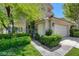 Inviting entrance with mature landscaping, a wrought iron fence, and a view of the attached two-car garage at 916 Pro Players Dr, Las Vegas, NV 89134