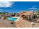 Backyard featuring a sparkling pool, covered patio, and desert landscaping with mountain views at 9337 Quail Ridge Dr, Las Vegas, NV 89134