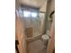 Bathroom featuring a walk-in shower with frosted doors, toilet, and decorative wreath at 9816 Villa Ridge Dr, Las Vegas, NV 89134