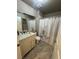 Bright bathroom featuring a vanity with a marble countertop and shower with floral curtain at 9816 Villa Ridge Dr, Las Vegas, NV 89134