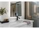 Modern bathroom featuring a black faucet, sleek countertop, and a stylish, lighted mirror at 11009 Summers End Ave, Las Vegas, NV 89134