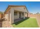 Exterior view of a home with a covered patio, artificial grass, and a well-kept backyard at 12426 Mosticone Way, Las Vegas, NV 89141