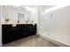 Modern bathroom features a glass-enclosed shower, wood-look flooring, and dual vanity sinks at 12426 Mosticone Way, Las Vegas, NV 89141