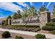 Stone entrance to Southern Highlands with manicured landscaping and colorful flower beds against a bright blue sky at 12426 Mosticone Way, Las Vegas, NV 89141