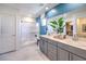 Bright bathroom with double vanity, walk-in shower with a glass door, and a large mirror at 1289 Miller Springs Ln # 96, North Las Vegas, NV 89084