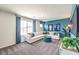 Bonus room with carpet, sectional sofa, blue curtains and an accent wall with a TV at 1289 Miller Springs Ln # 96, North Las Vegas, NV 89084