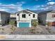 Charming two-story home with a blue garage door and desert landscaping at 1289 Miller Springs Ln # 96, North Las Vegas, NV 89084
