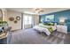 Main bedroom with a blue accent wall, ceiling fan, carpet, and a bright window at 1289 Miller Springs Ln # 96, North Las Vegas, NV 89084
