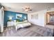 Main bedroom with a blue accent wall, ceiling fan, carpet, and two bedside tables at 1289 Miller Springs Ln # 96, North Las Vegas, NV 89084