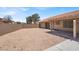 View of the gravel backyard area with access to a covered patio with the home at 1613 Glenrosa Dr, North Las Vegas, NV 89031