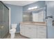 Well-lit bathroom with a stand-alone shower, toilet, and vanity featuring white cabinetry at 1613 Glenrosa Dr, North Las Vegas, NV 89031