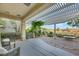 Inviting covered patio with stone flooring, a pergola, and lush landscaping offers serene outdoor living at 1805 Prichard Ave, Henderson, NV 89052