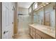 Bright bathroom featuring a double sink vanity, a glass-enclosed shower, and natural lighting at 1904 Hot Oak Ridge St, Las Vegas, NV 89134