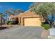 Beige home featuring desert rock landscaping, an attached two-car garage, and a driveway at 1904 Hot Oak Ridge St, Las Vegas, NV 89134