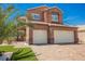 Charming two-story home with a well-maintained lawn, mature palm trees, and a three-car garage at 209 Camino Vista St, Henderson, NV 89012