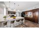 Modern kitchen with dark wood cabinets, white countertops, a kitchen island with barstools and stainless steel appliances at 209 Camino Vista St, Henderson, NV 89012