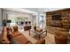 Living room boasts hardwood floors, leather furniture, a wood accent wall, and sliding doors to a gorgeous backyard and pool at 209 Camino Vista St, Henderson, NV 89012