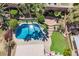 Aerial view of a backyard oasis with a sparkling pool, lush landscaping, and charming stone features at 209 Camino Vista St, Henderson, NV 89012